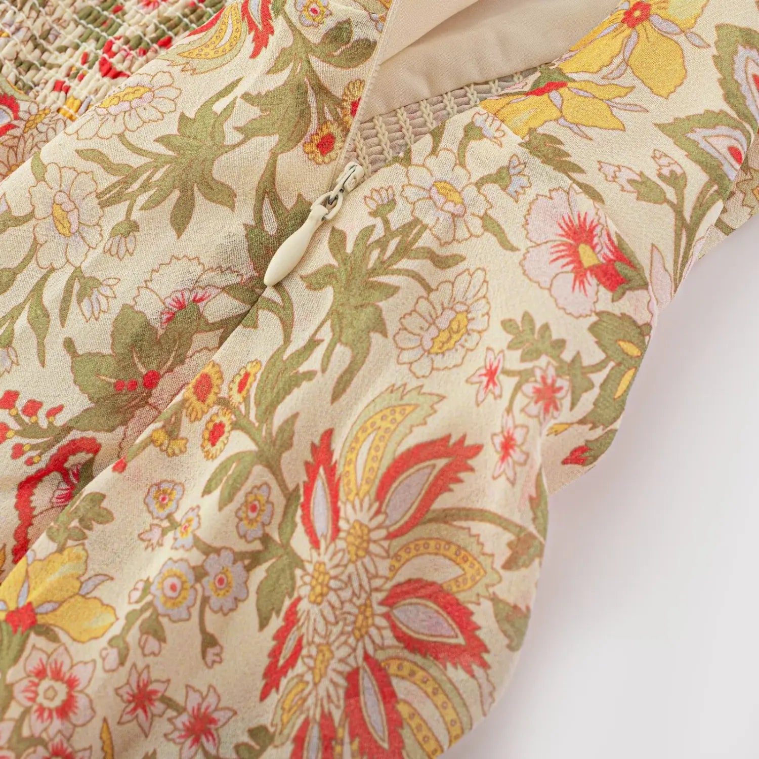 Partial close shot of side invisible white zipper on vintage floral slip mini dress, adjacent elastic smocked back waist panel with soft cream lining