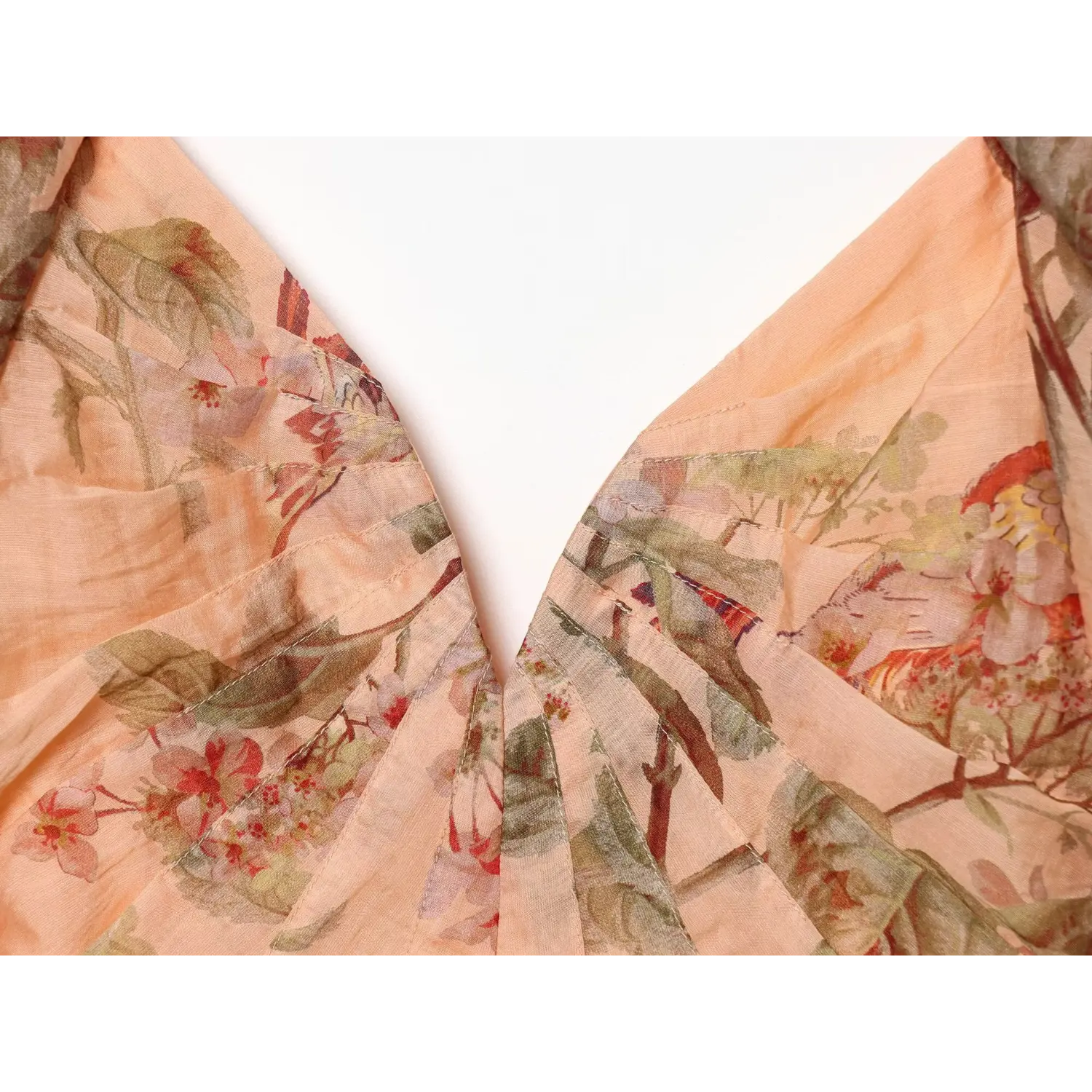 Close‑up of front bust ruched stitching, deep v plunge, peach floral bird print woven fabric