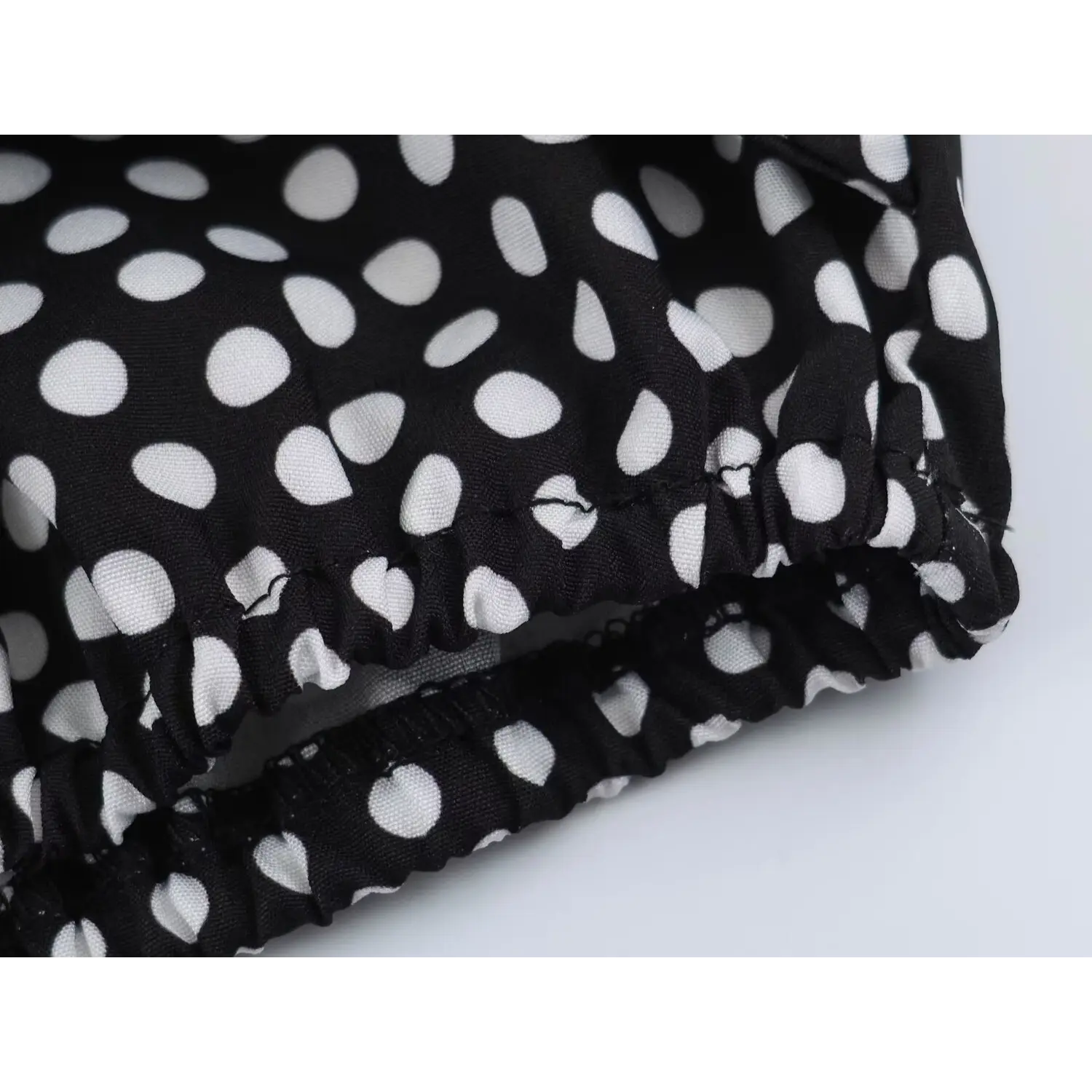 Bottom elastic hem full flat shot, gathered stretch ruffle edge, allover black white polka dot print