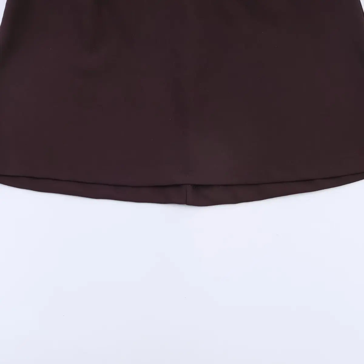 Close-up of the bottom hem on a brown V-neck cap sleeve dress, showing the double-folded stitching and even finish.