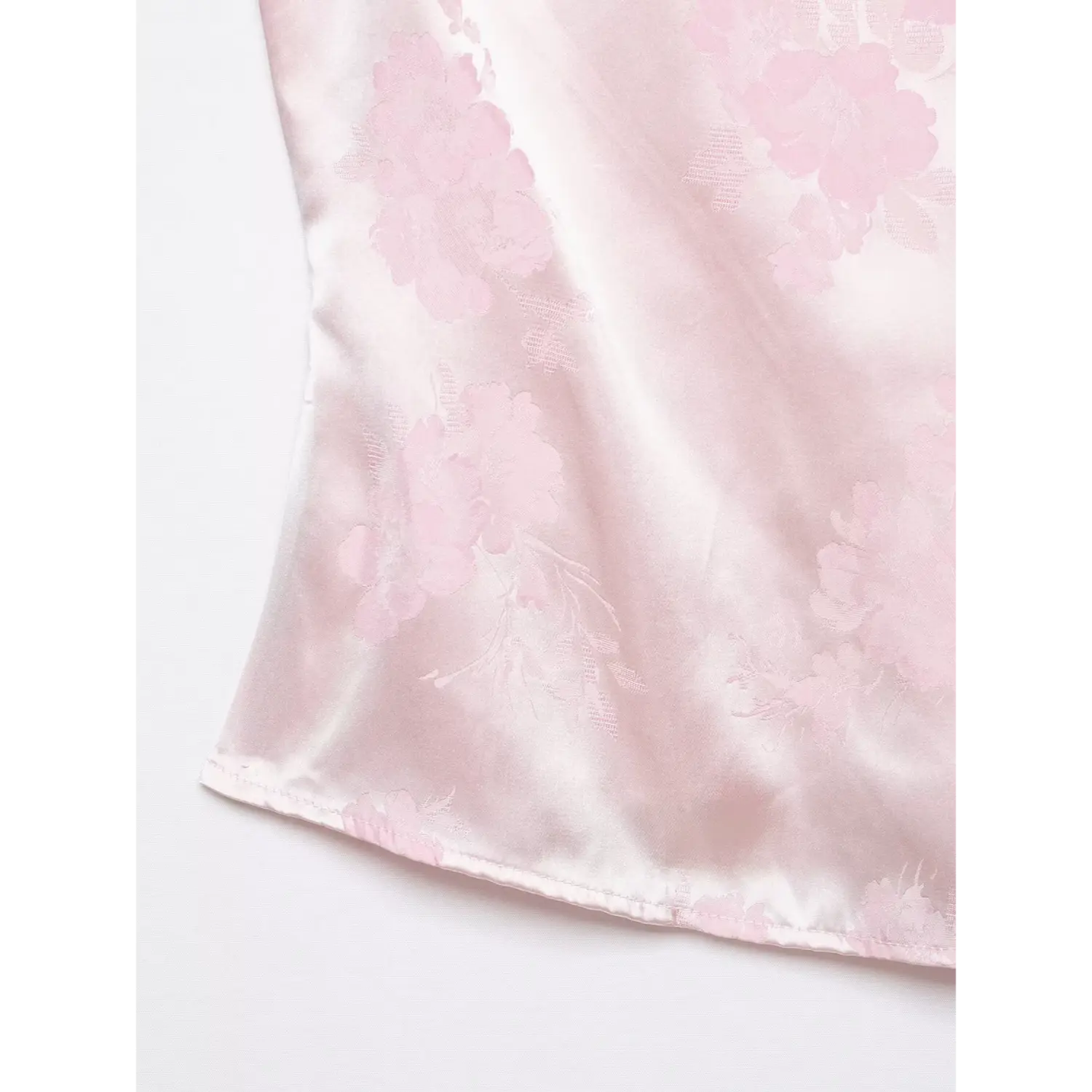 Lower hem close-up, straight finished hem, light pink floral jacquard satin woven texture