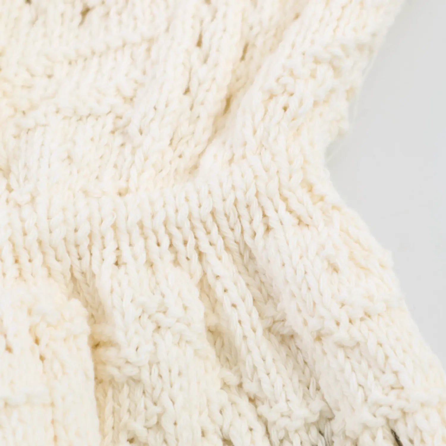 Folded shot showcasing see-through hollow knit construction and soft fabric drape