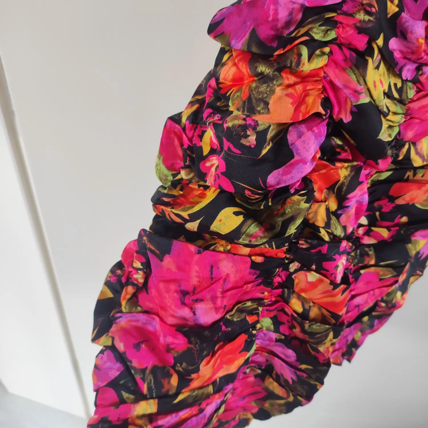 Macro close‑up side ruched fabric texture black base vivid floral print mini dress