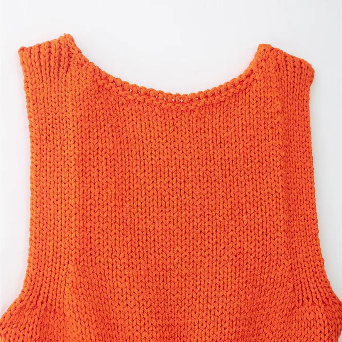 Back view of the bright orange knit cami, showing the simple scoop neck and smooth vertical knit