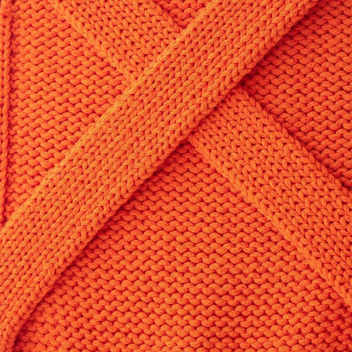 Close-up of the chunky knit fabric, showing the crisscross wrap design and textured stitch pattern