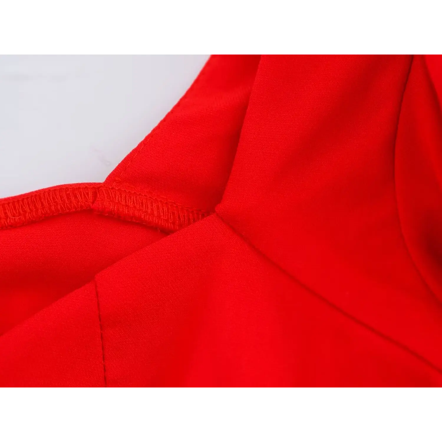 Close-up of inner armhole seam and stitching detail on bright red puff sleeve corset top