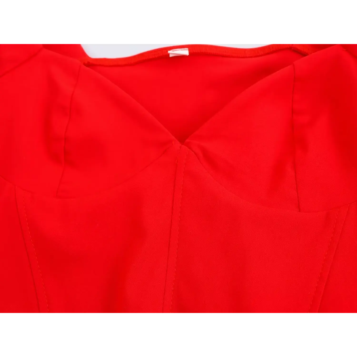 Close-up of bustier-style seam and V-cut neck detail on bright red corset top