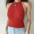 Front lifestyle shot on model, bright red draped halter cropped tank top, bust gathering, ruched waist, matched with light blue denim and thick chain necklace, chic casual summer outfit
