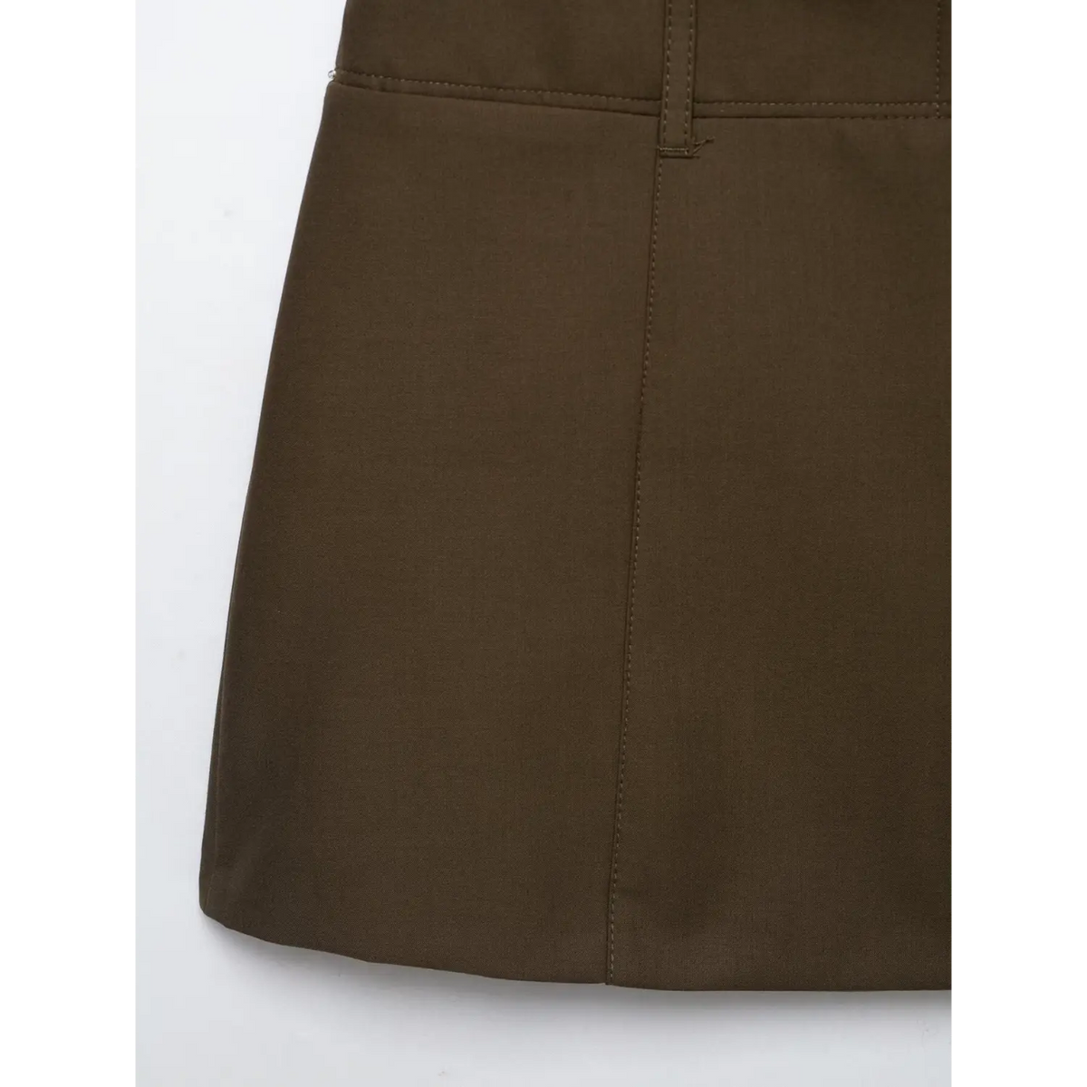 Close-up of skirt panel seam on brown mini dress