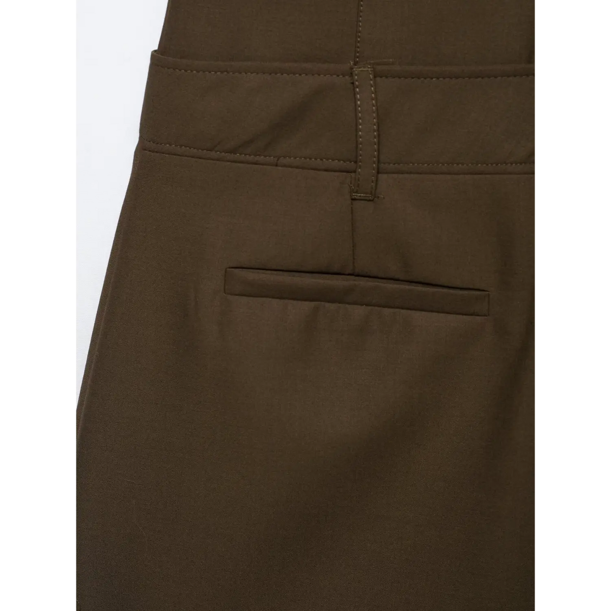 Close-up of back welt pocket detail on brown mini dress