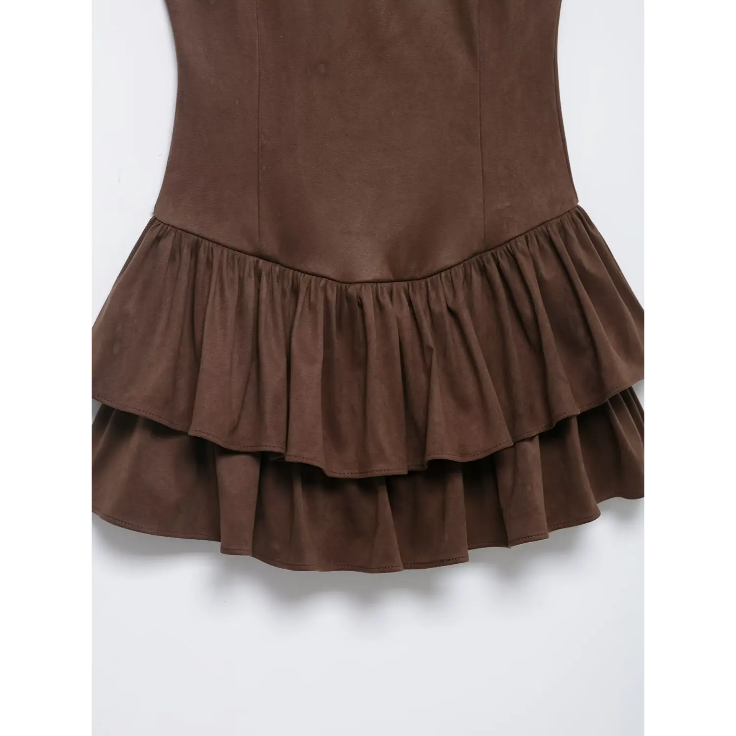 Close-up of double layered ruffle hem on brown faux suede sleeveless mini dress