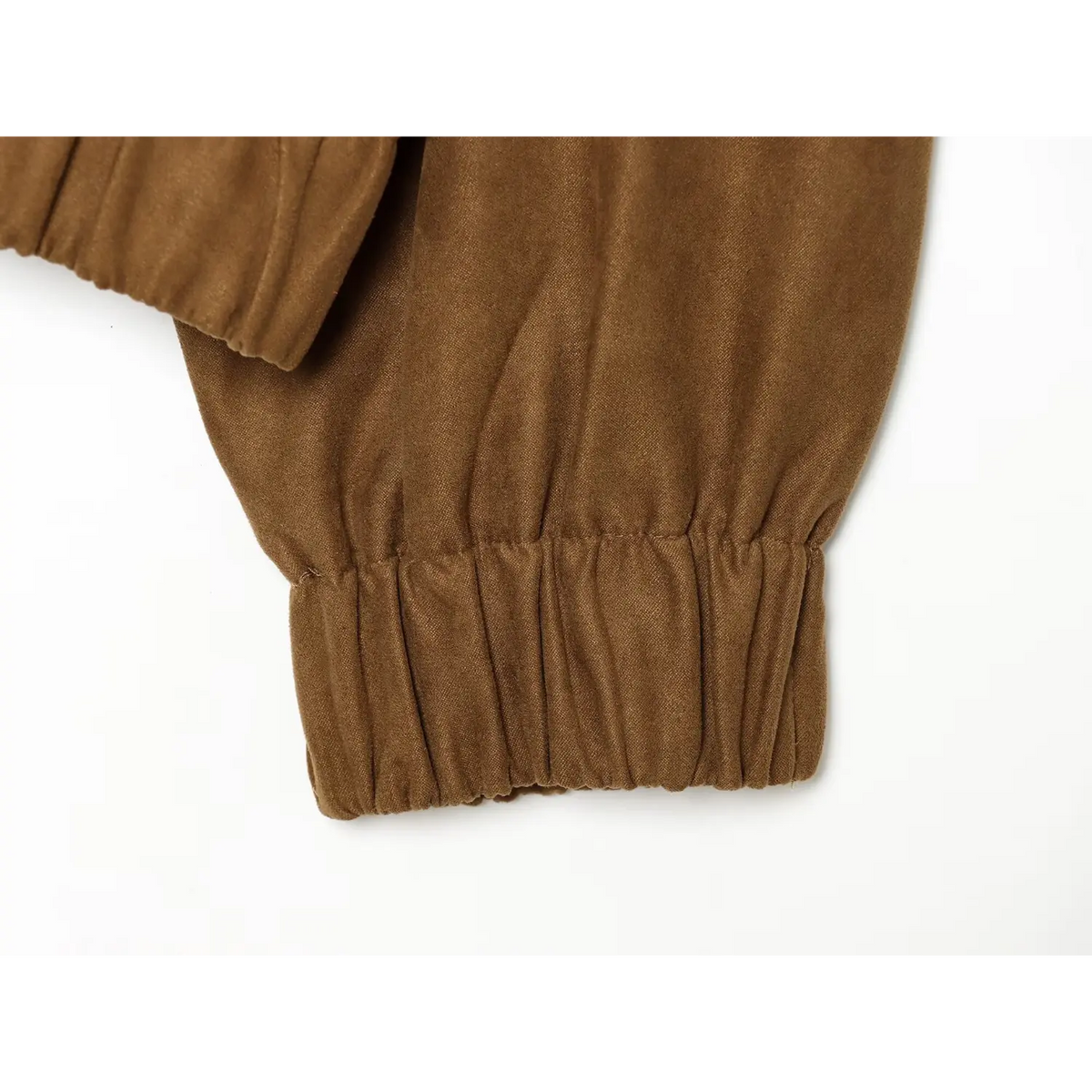 Close-up of elastic gathered cuff on sleeve of brown faux suede embroidered bomber jacket
