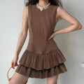 Model lifestyle shot wearing brown sleeveless faux suede mini dress with double ruffle hem