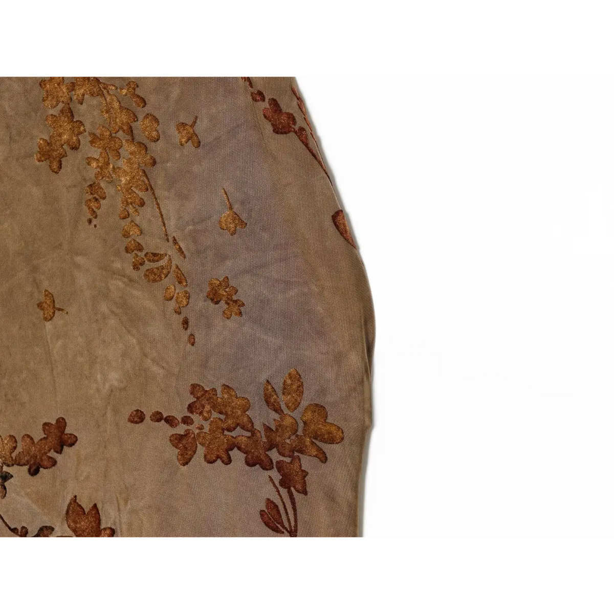 Macro detail of brown floral print on sheer chiffon fabric with soft draped texture
