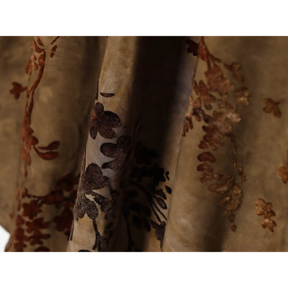 Close‑up of flowy fabric drape, brown floral pattern and sheer chiffon layers