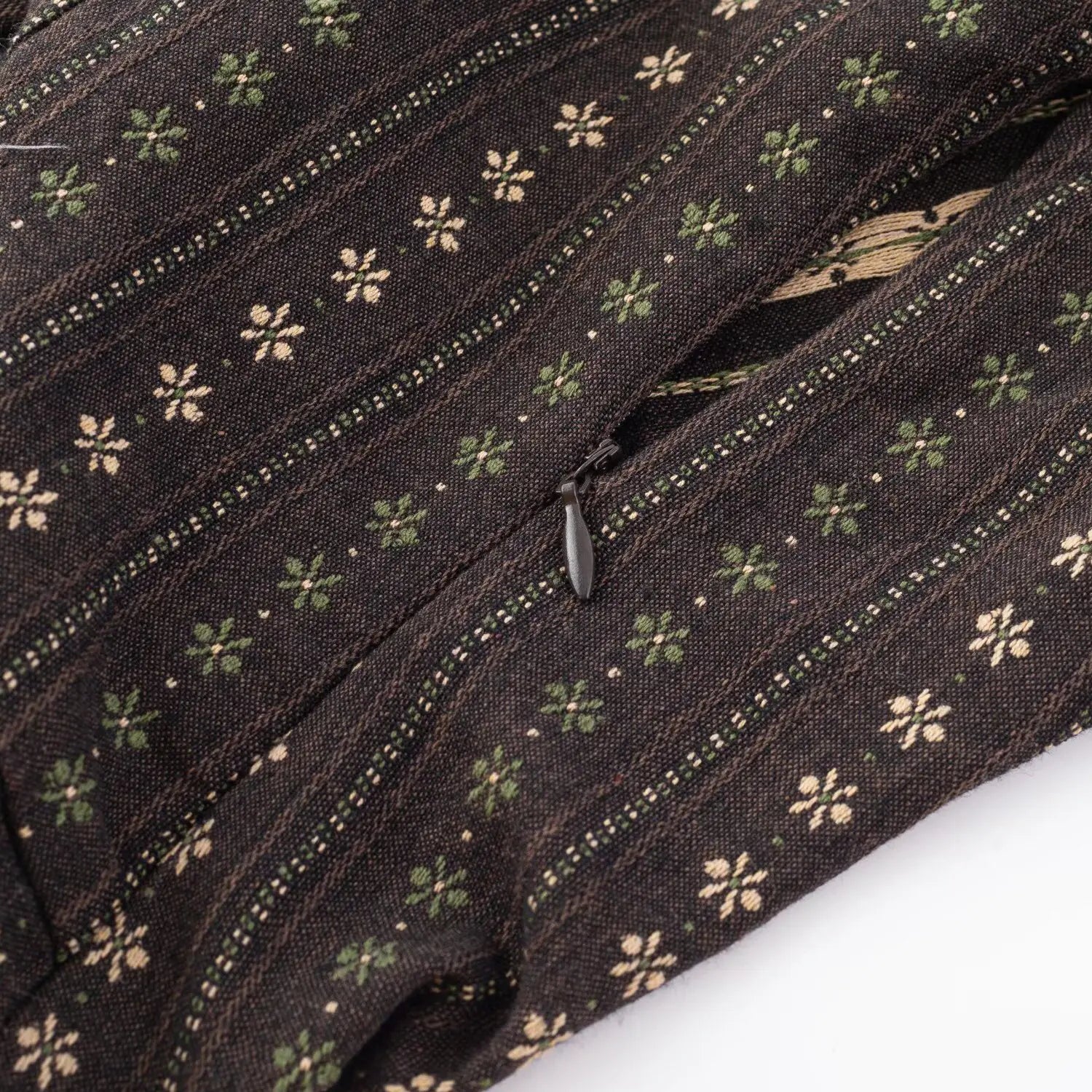 Dark brown floral crop top back close-up, invisible black zipper and stitched woven fabric seam flat lay detail