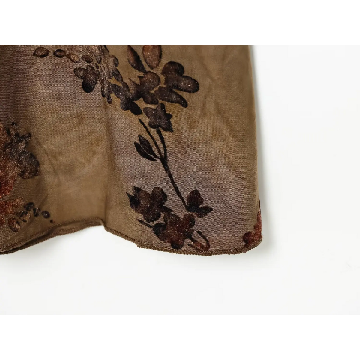 Close‑up of skirt hem, brown floral print and lightweight chiffon texture