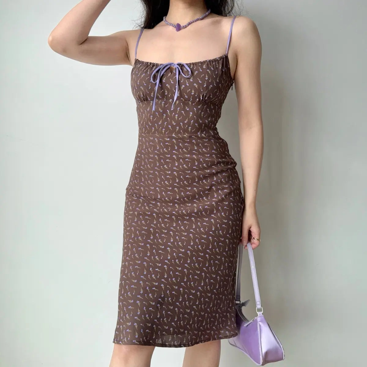 The brown floral midi dress paired with a purple beaded necklace, highlighting the neckline.