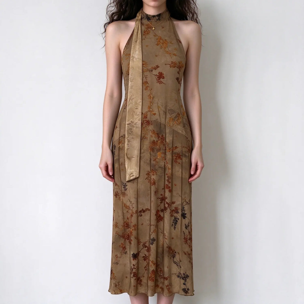 Model wearing brown floral print halter maxi dress with neck tie, slim fit, vintage floral pattern, white background