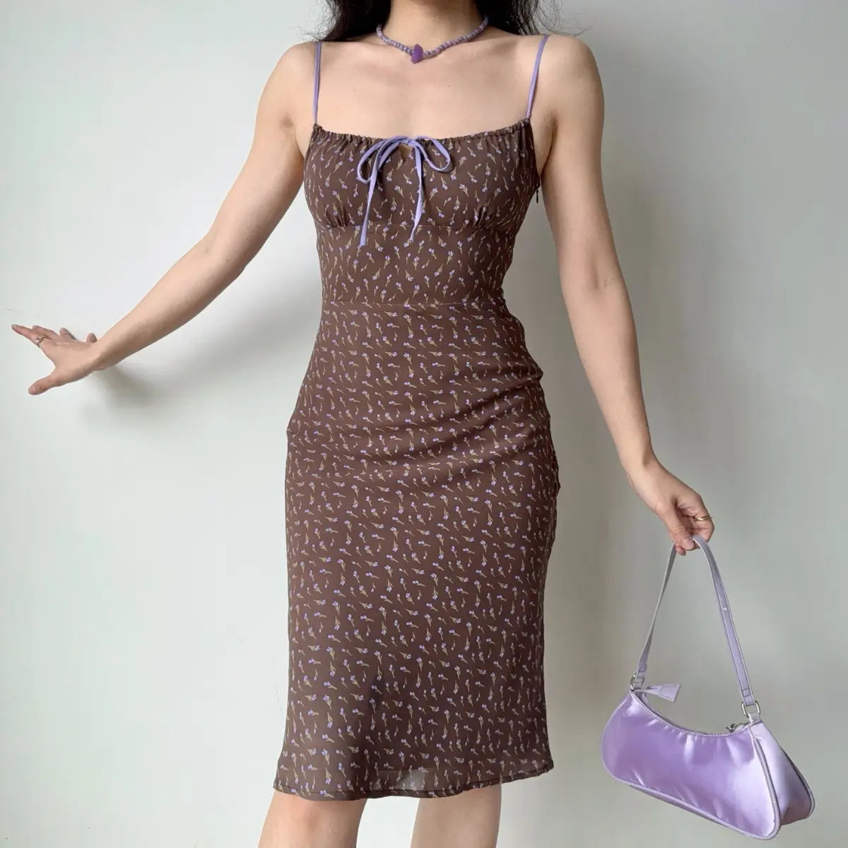 Front view of the brown floral midi dress with purple straps and a bow detail.