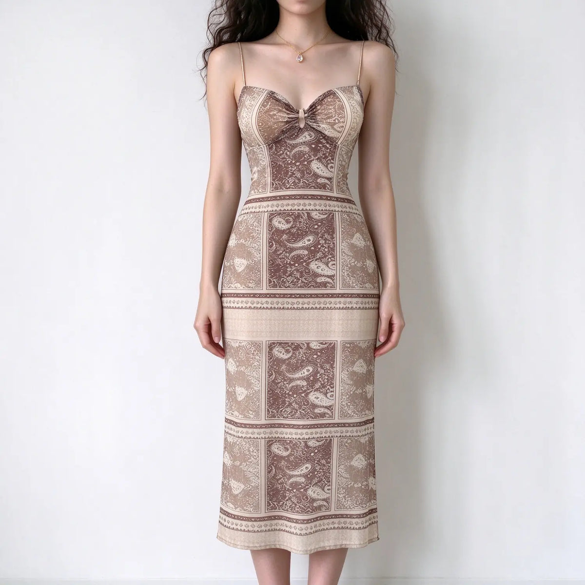Model in brown paisley print spaghetti strap maxi dress, sweetheart neck with front cutout, slim bodycon maxi skirt, white backdrop