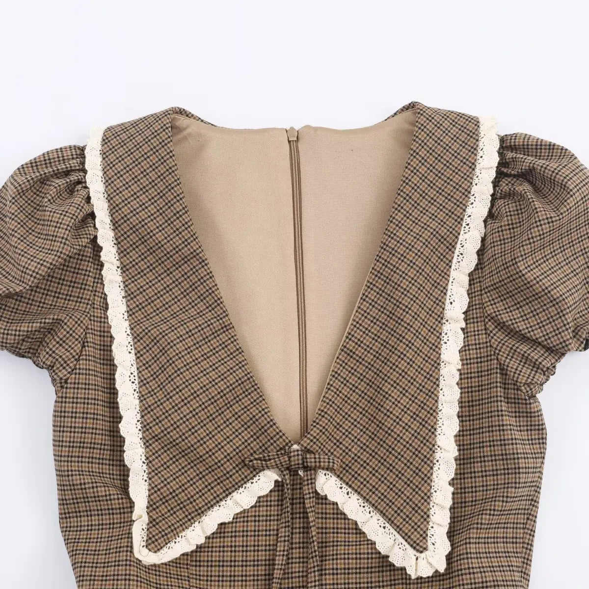 Close-up of the back V-neckline and zipper on a brown plaid dress, showing the large sailor collar and lace trim.