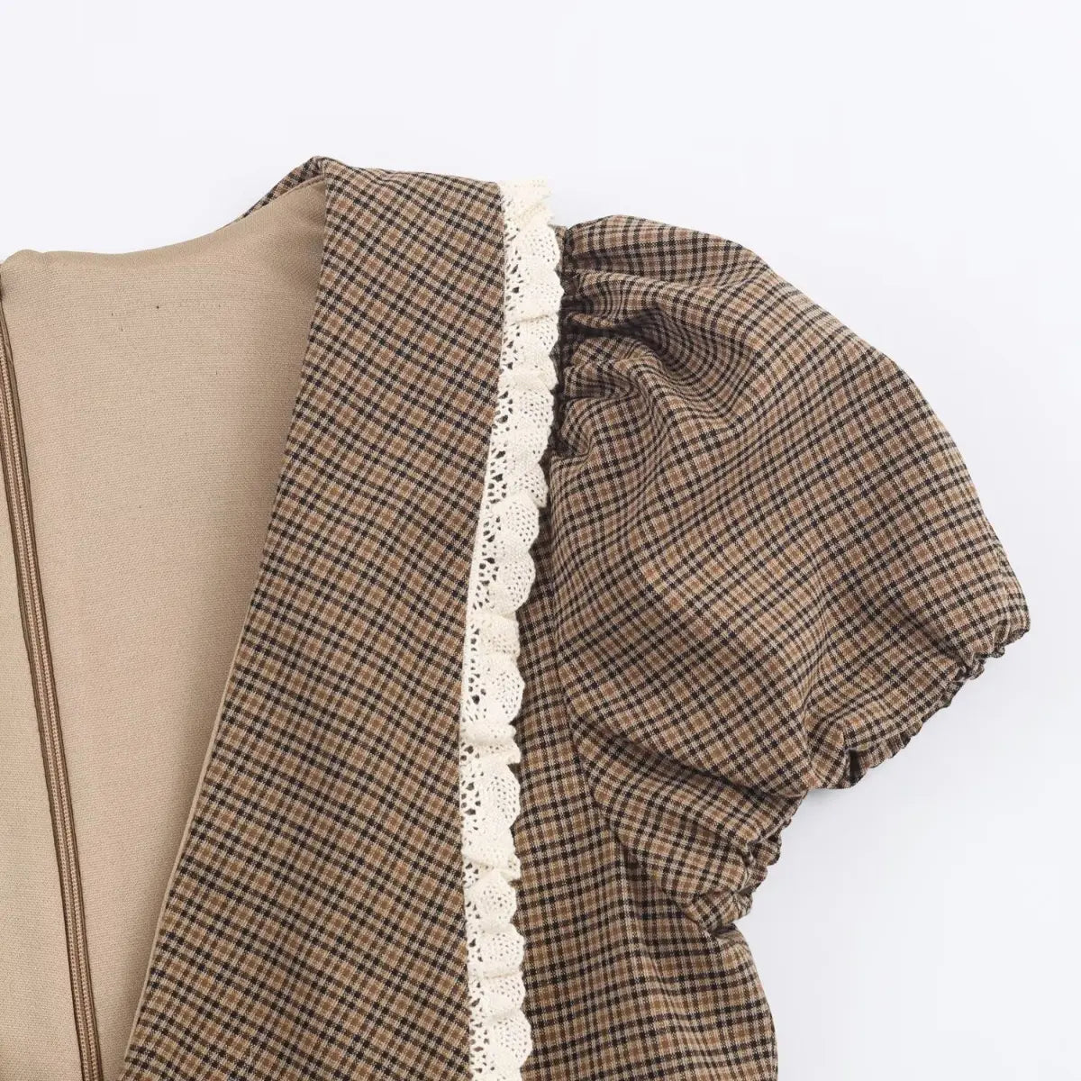 Close-up of the sailor collar and white lace trim on a brown plaid dress, showing the puff sleeve detail.