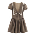 Front view of a brown, black, and beige plaid dress with a large sailor collar trimmed in white lace, puff sleeves, and a gathered skirt.