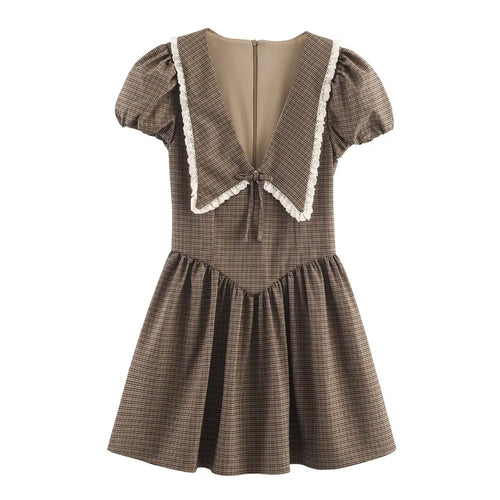 Front view of a brown, black, and beige plaid dress with a large sailor collar trimmed in white lace, puff sleeves, and a gathered skirt.