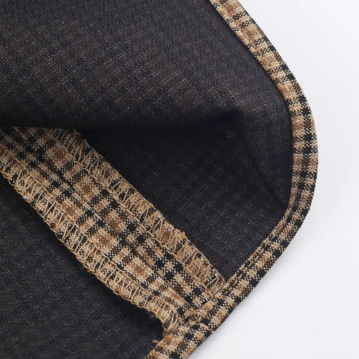 Close-up of the inner lining and seam construction on a brown plaid dress.