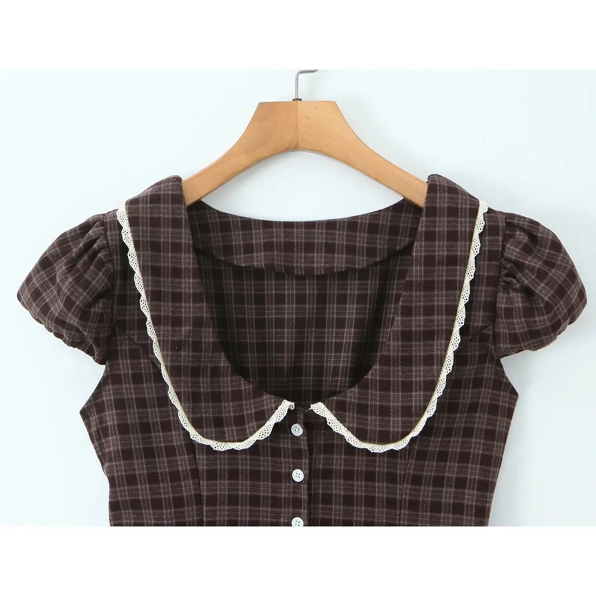 Close-up of the Peter Pan collar with delicate lace trim and puff sleeve construction.