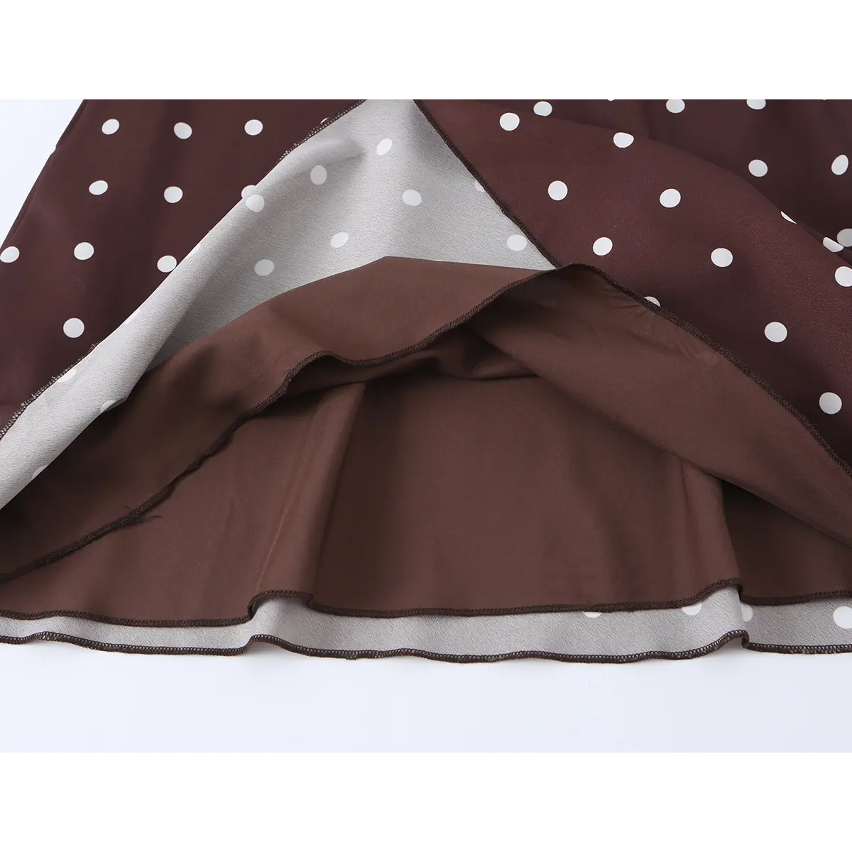 Detailed view of the fabric lining of brown polka dot dress, showing double-layer construction and soft inner material.