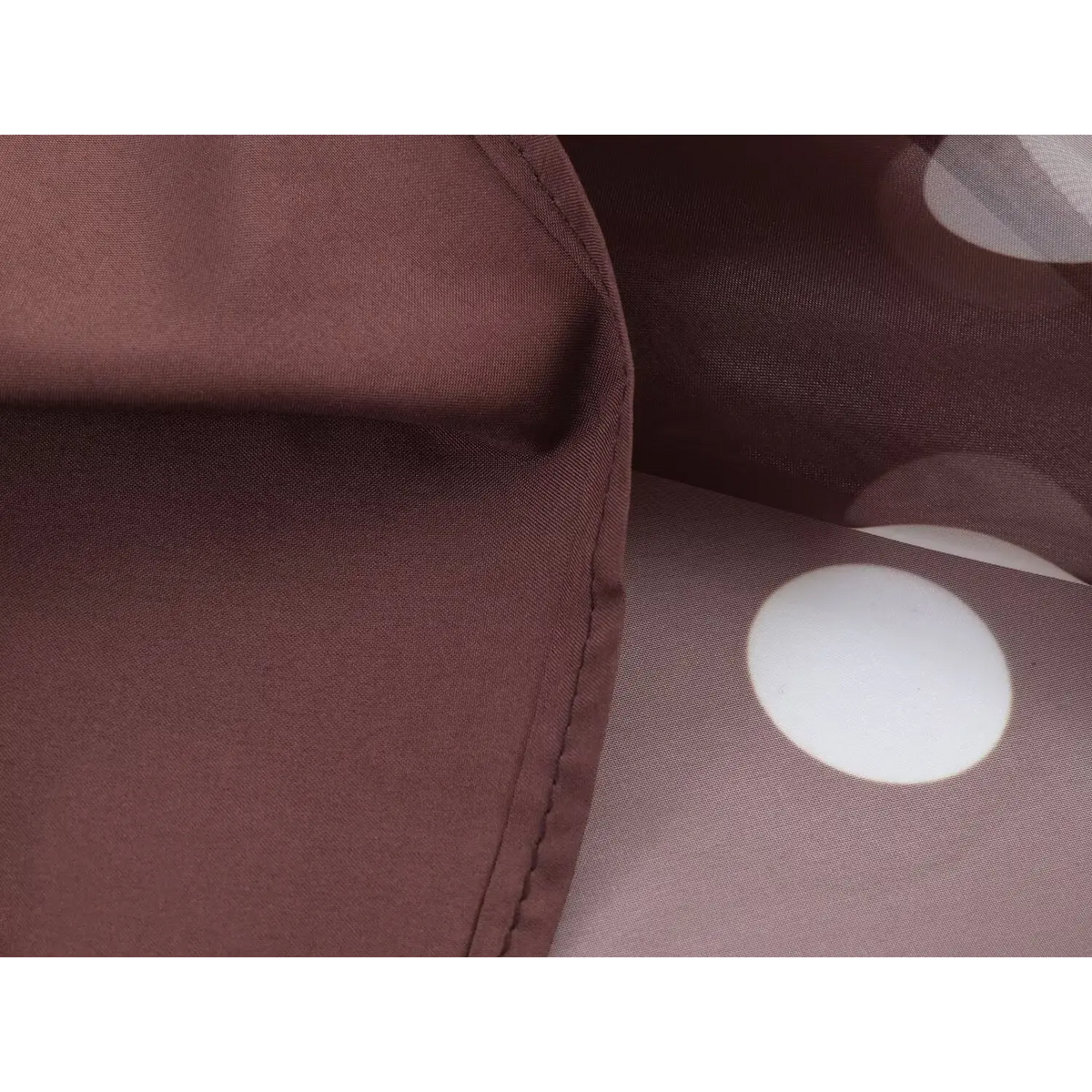 Close-up of inner lining and stitching seam of brown white polka dot maxi dress, smooth solid brown lining fabric