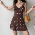  Model wearing brown polka dot mini dress with a rattan bag, showing casual everyday styling and flattering fit.