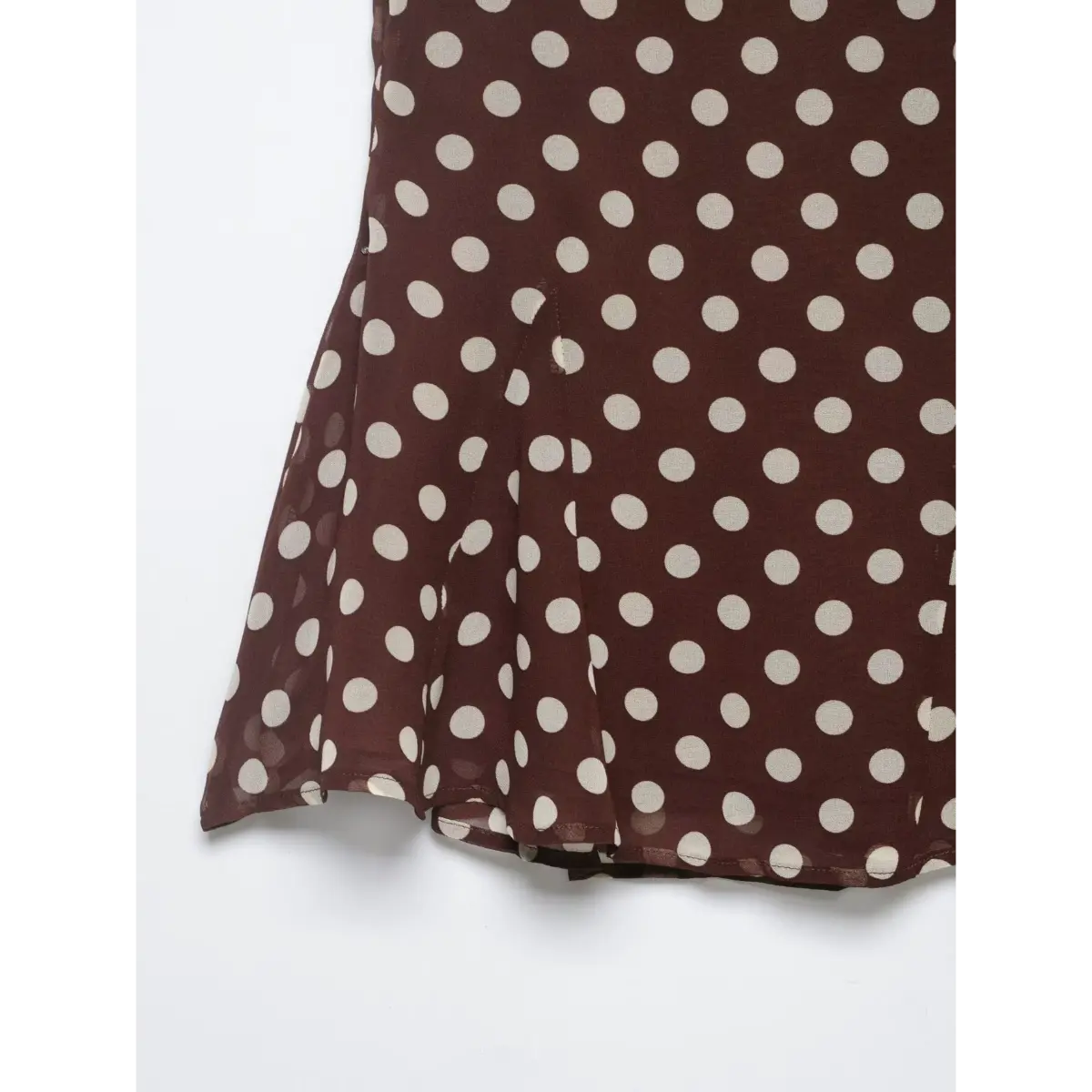Close-up of the flared ruffled hem and lightweight fabric texture on the brown polka dot skirt