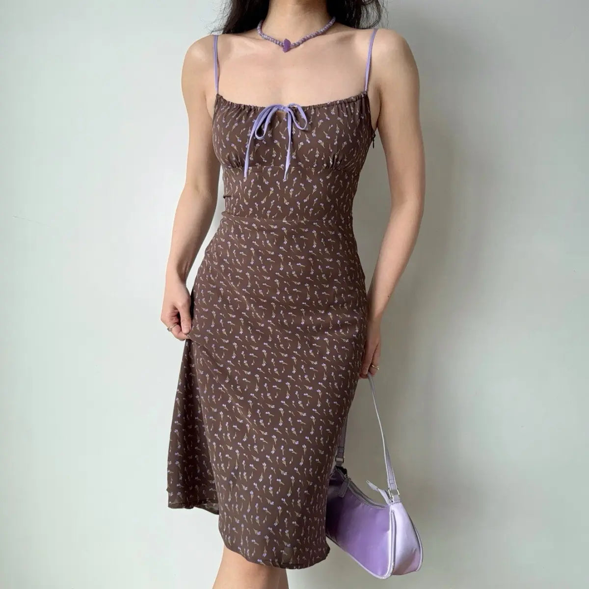 The brown floral midi dress styled with a lavender satin handbag.