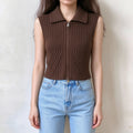 Model wearing brown ribbed knit sleeveless vest with lapel collar and full front zipper, cropped fitted style, paired with light blue jeans, front view
