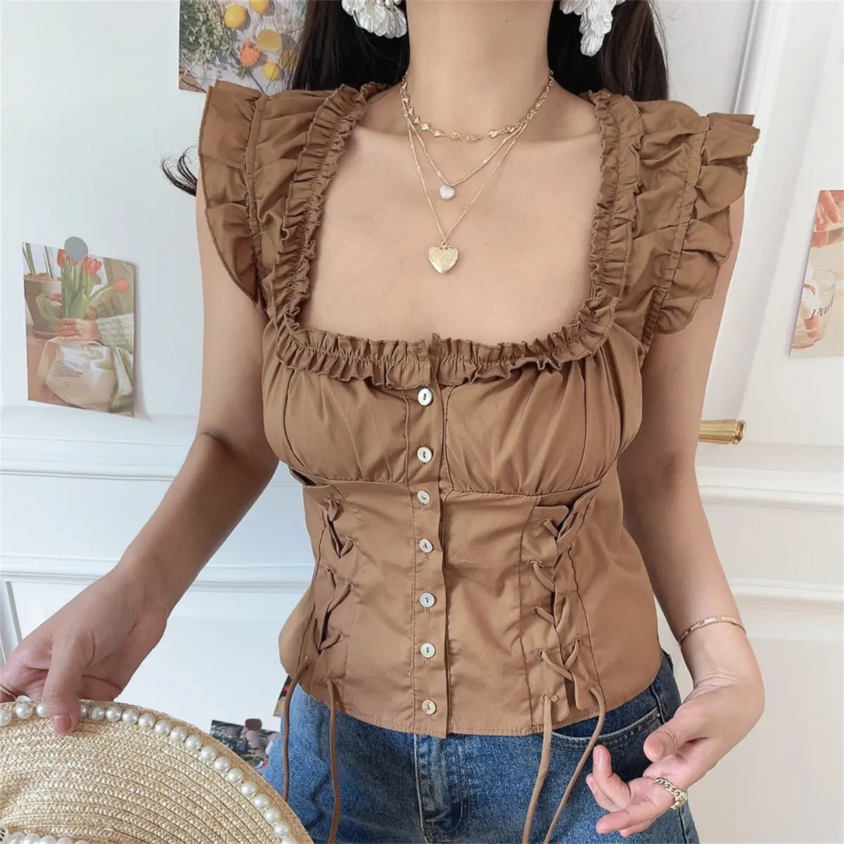 Close-up side view of adjustable lace-up drawstring on coffee brown sleeveless frill corset blouse.