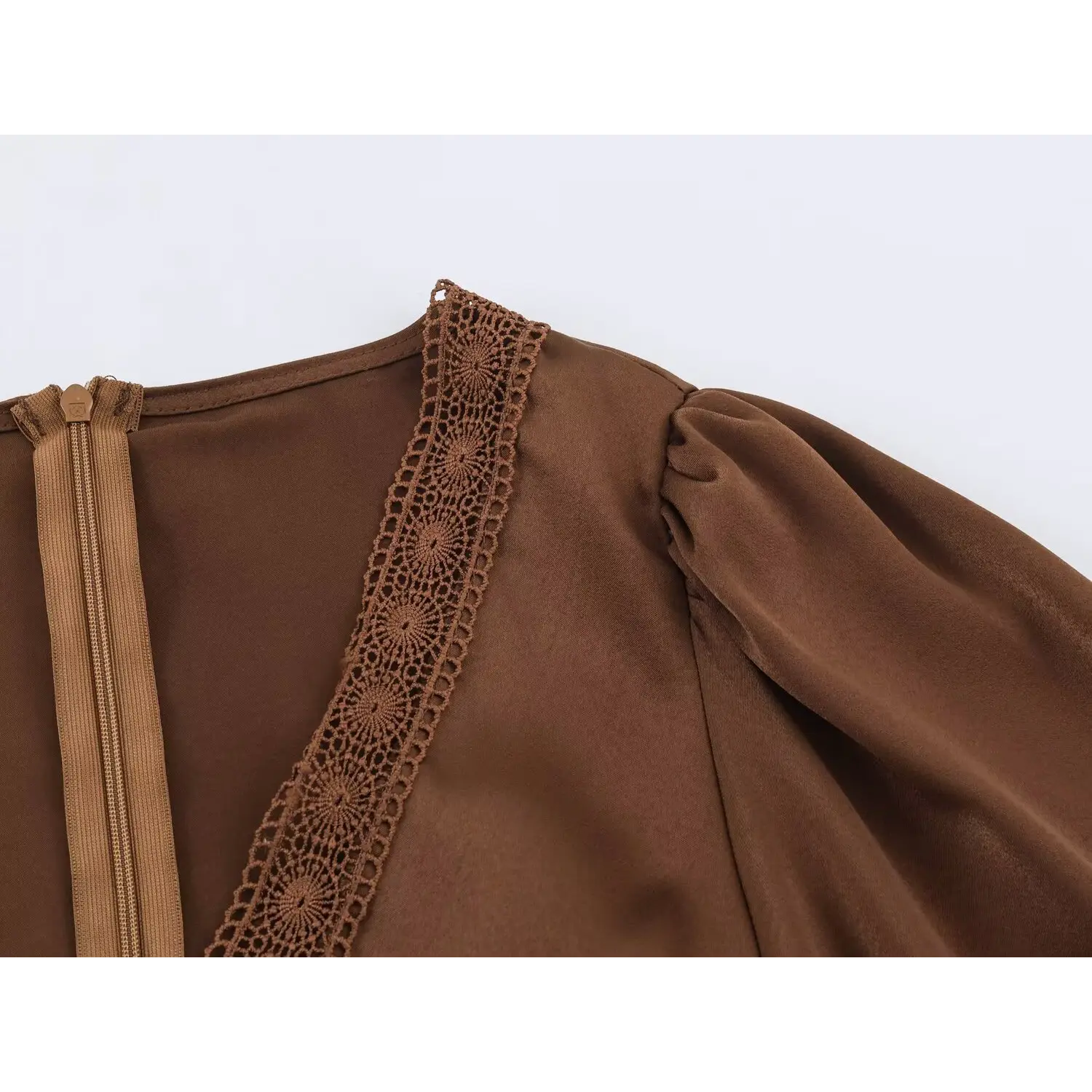 Macro shot of lace trim along v‑neck shoulder edge brown satin maxi dress