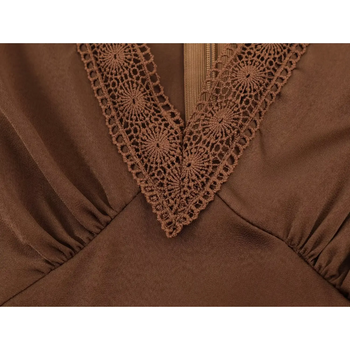 Close‑up of v‑point lace trim and bust gathering on brown satin maxi dress