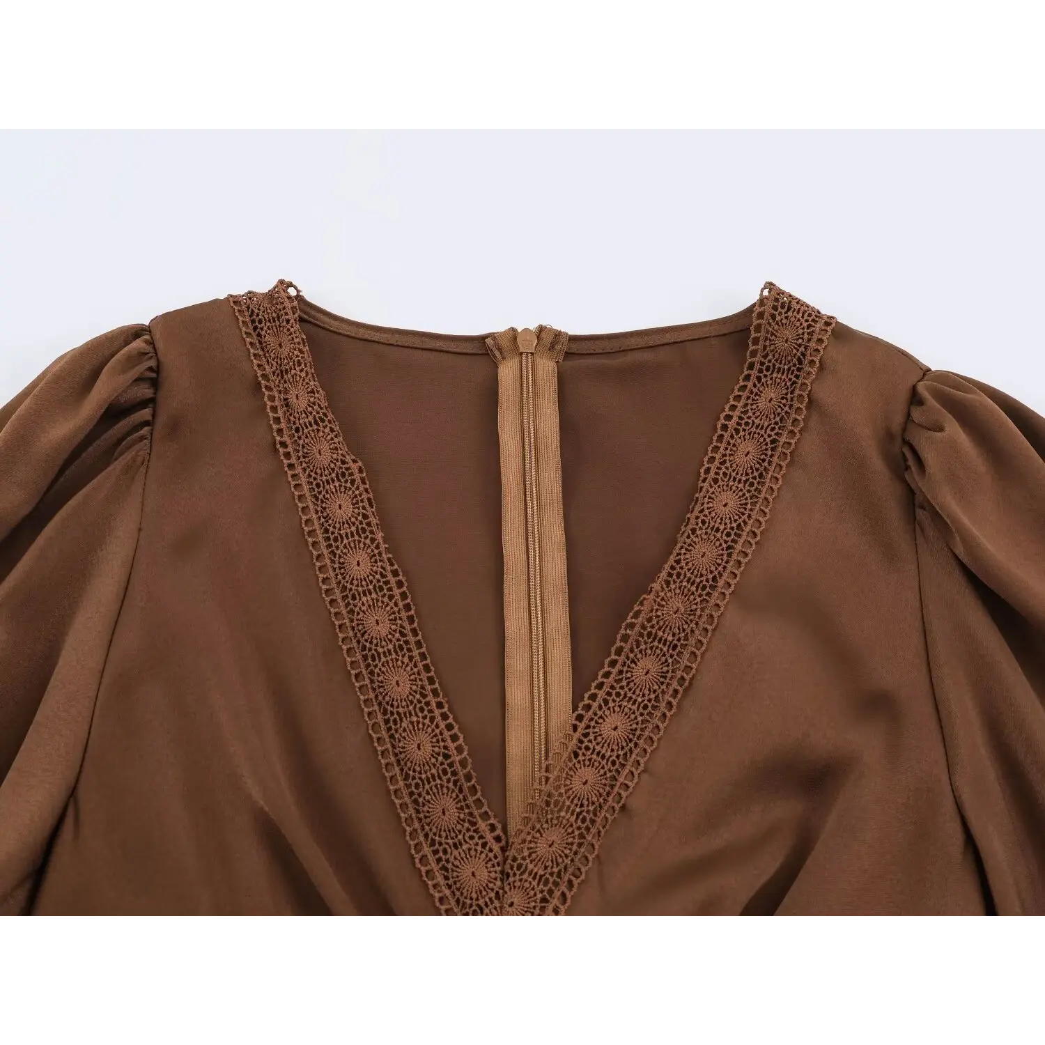 Close‑up of v‑neck lace trim and back zipper on brown satin maxi dress