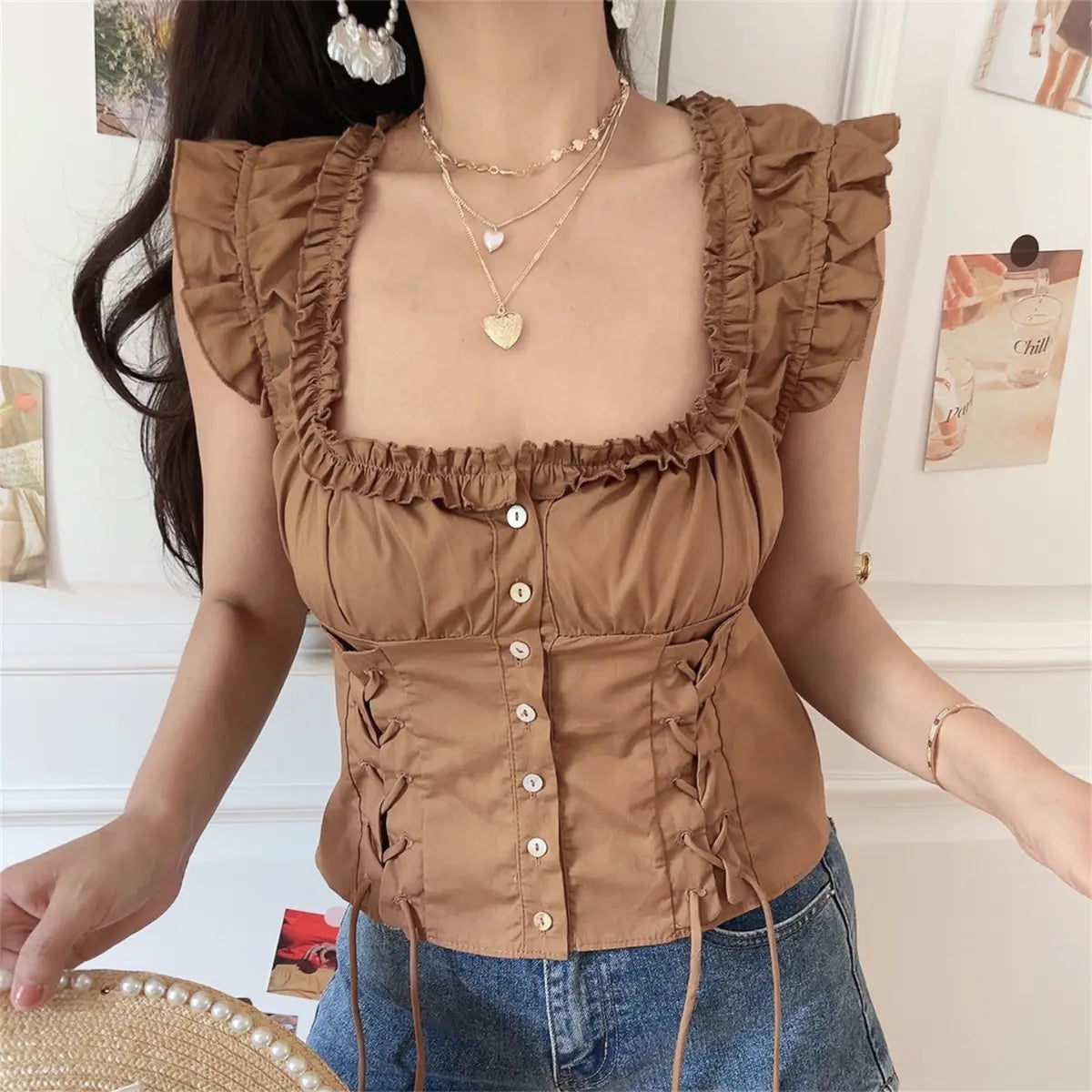 Back lifestyle view of coffee frilled corset blouse showing elasticated back and slim cropped fit.