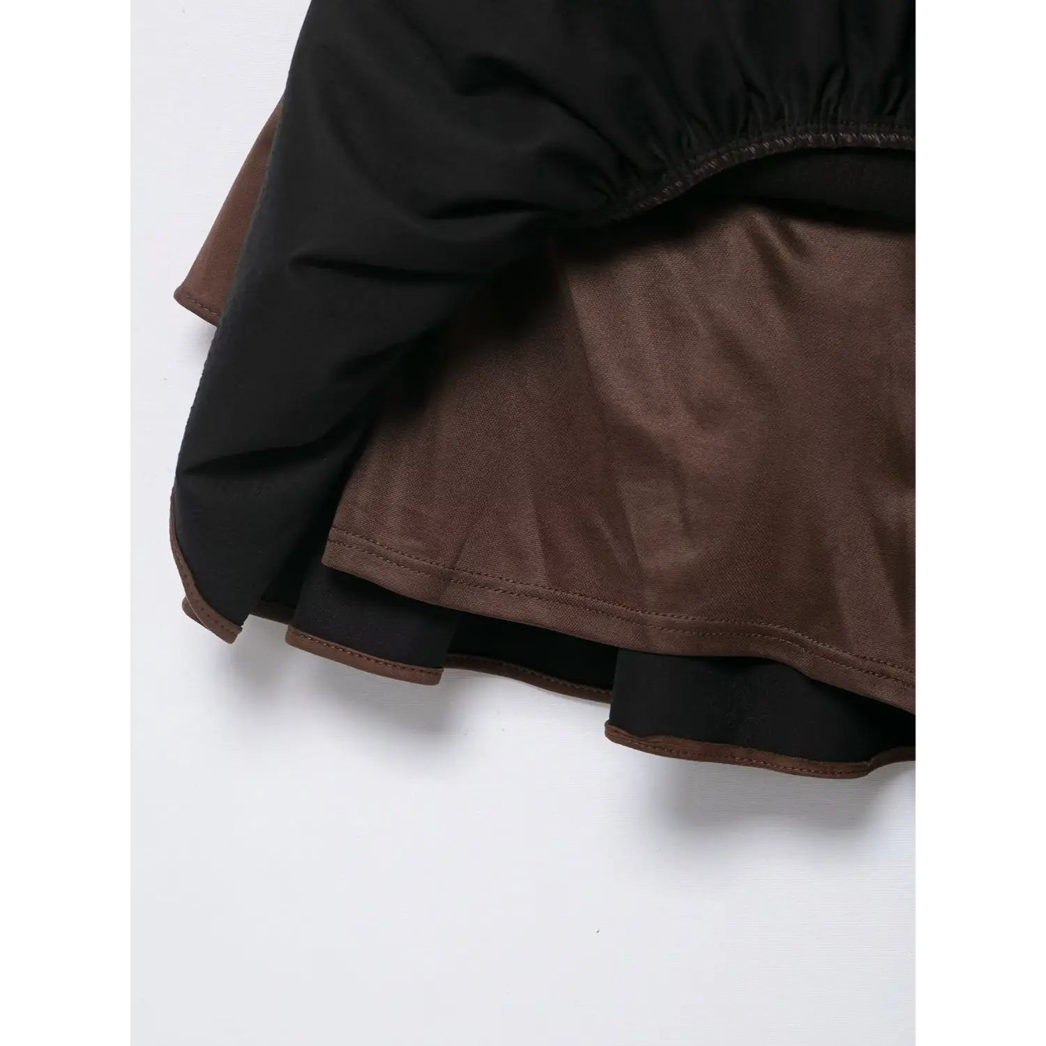 Close-up of built-in shorts lining under tiered ruffle skirt of brown faux suede dress