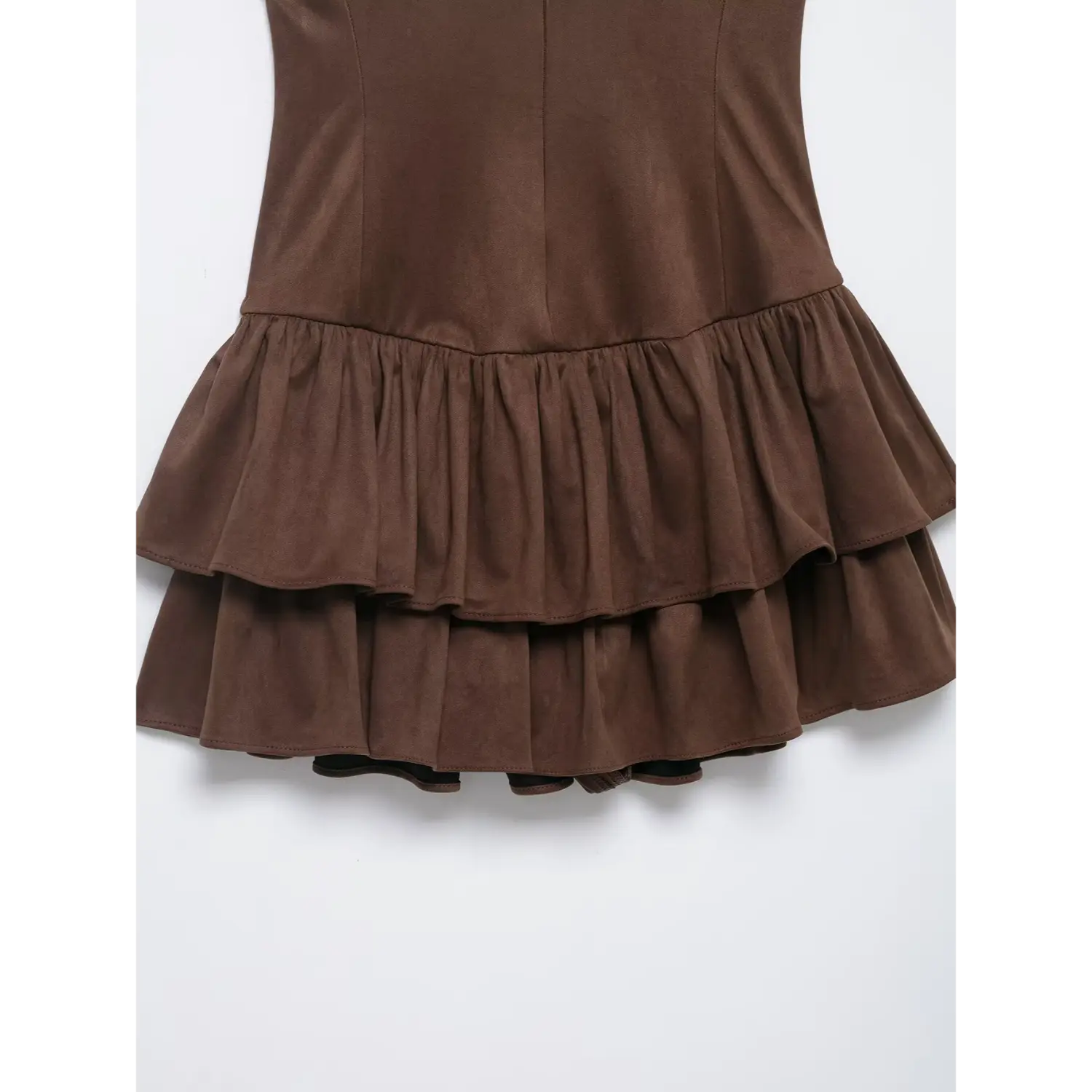 Close-up of fitted waist and two-layer ruffle skirt on brown sleeveless suede dress