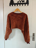Brown teddy fleece crew neck cropped sweatshirt hanging on door, front view