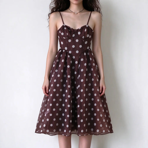 Female model front view wearing brown spaghetti strap maxi dress with white polka dots, sweetheart bust, sheer mesh fabric, A-line flared long skirt