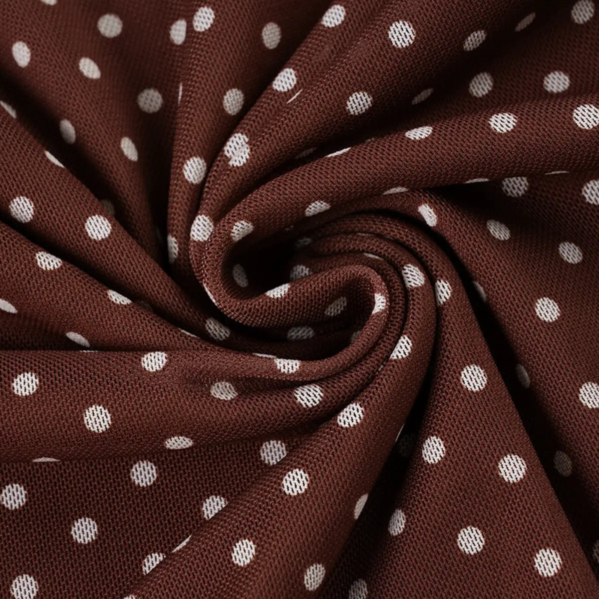 Close-up shot of the brown mesh fabric with white polka dots, showing the texture, drape, and print details.
