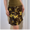 Close-up front view of a brown and yellow floral chiffon mini skirt, showing the print, fabric texture, and fit.