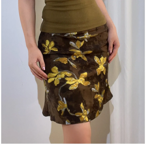 Close-up front view of a brown and yellow floral chiffon mini skirt, showing the print, fabric texture, and fit.