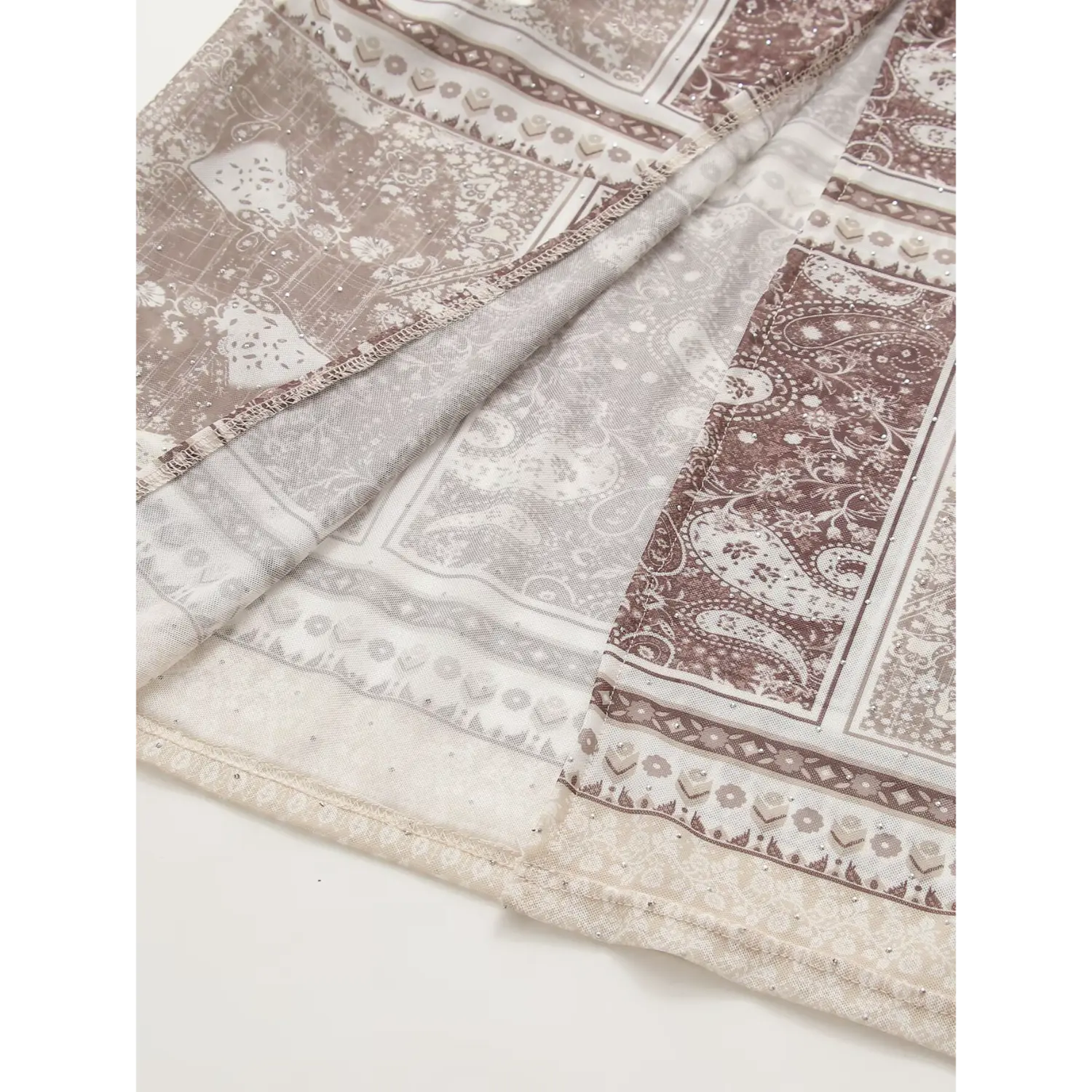 Close‑up of hem detail on brown vintage paisley print maxi dress